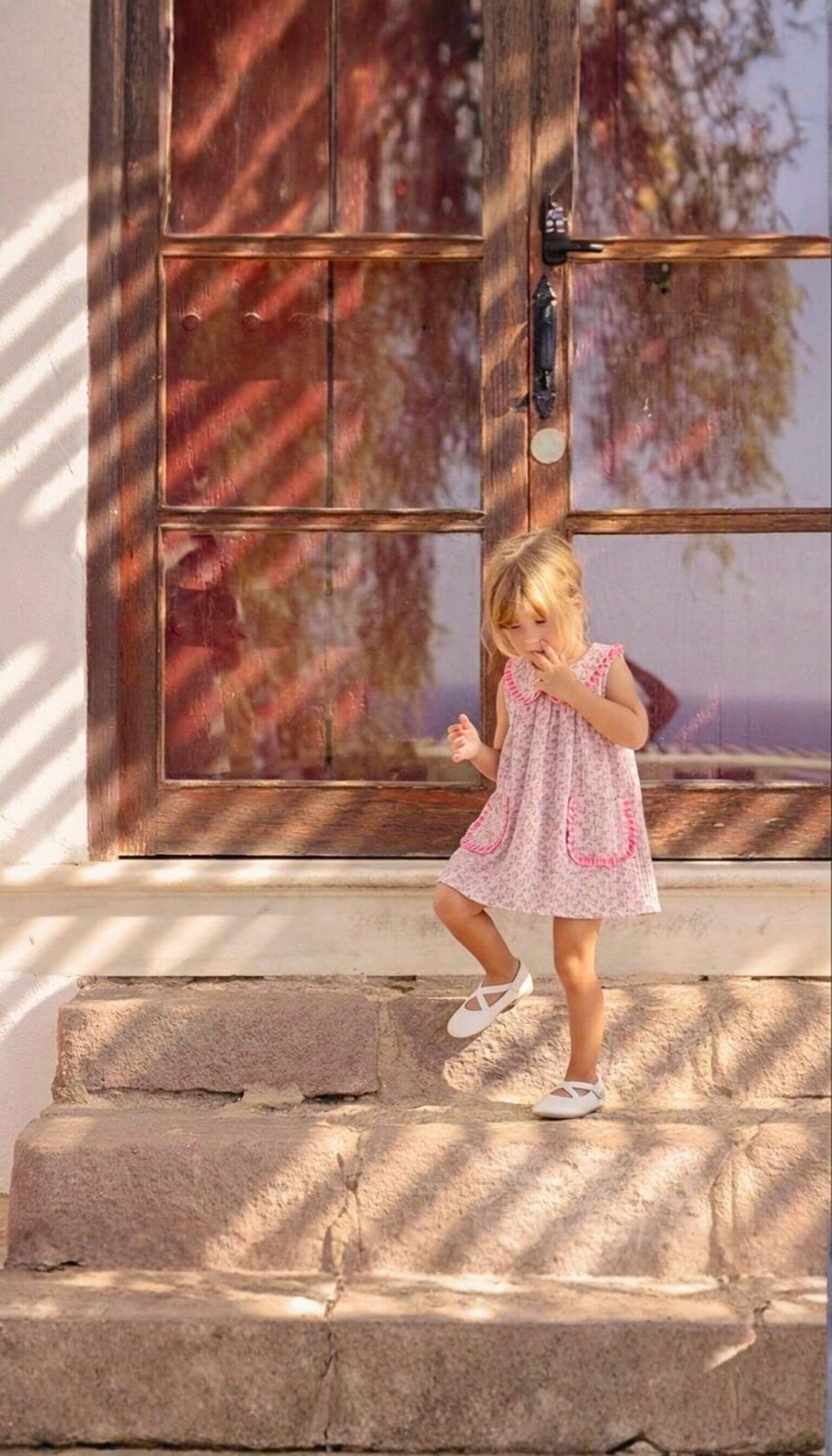 Vestido con bolsillos de niña, confeccionado en flores Tahiti con detalles rosa fucsia verano