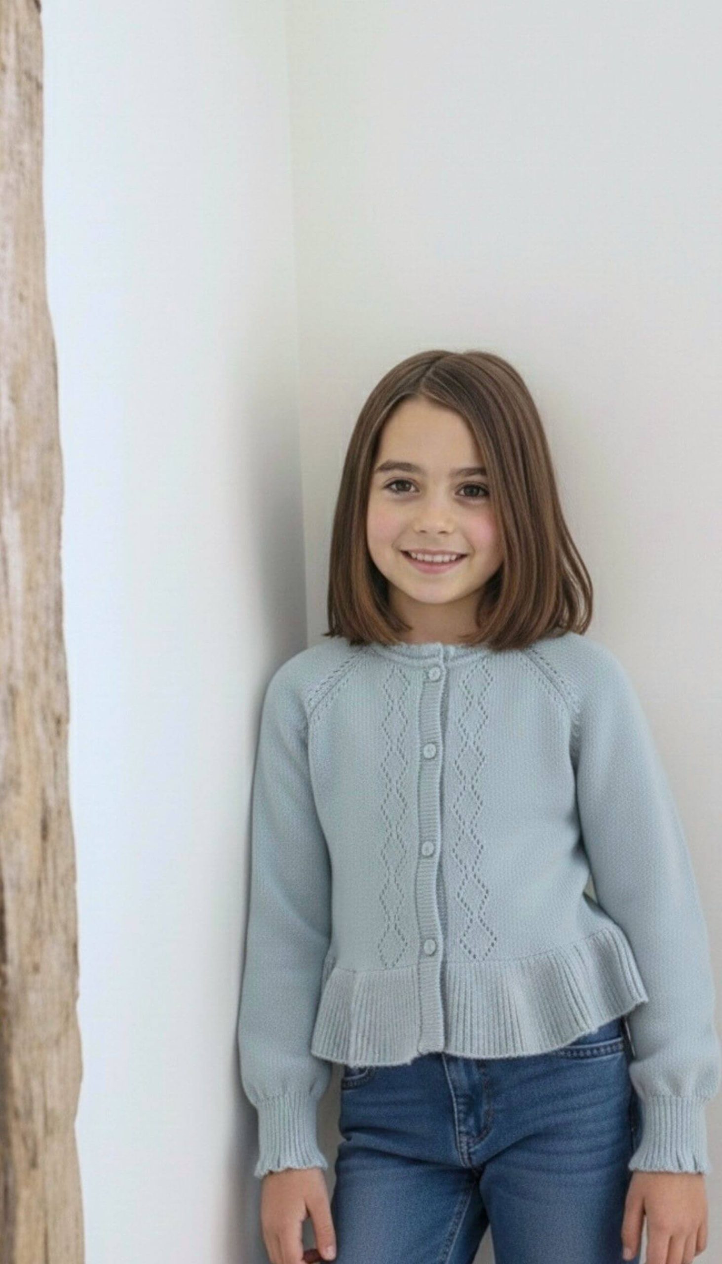 Jersey de punto azul para niña puesto en modelo infantil vista frontal.