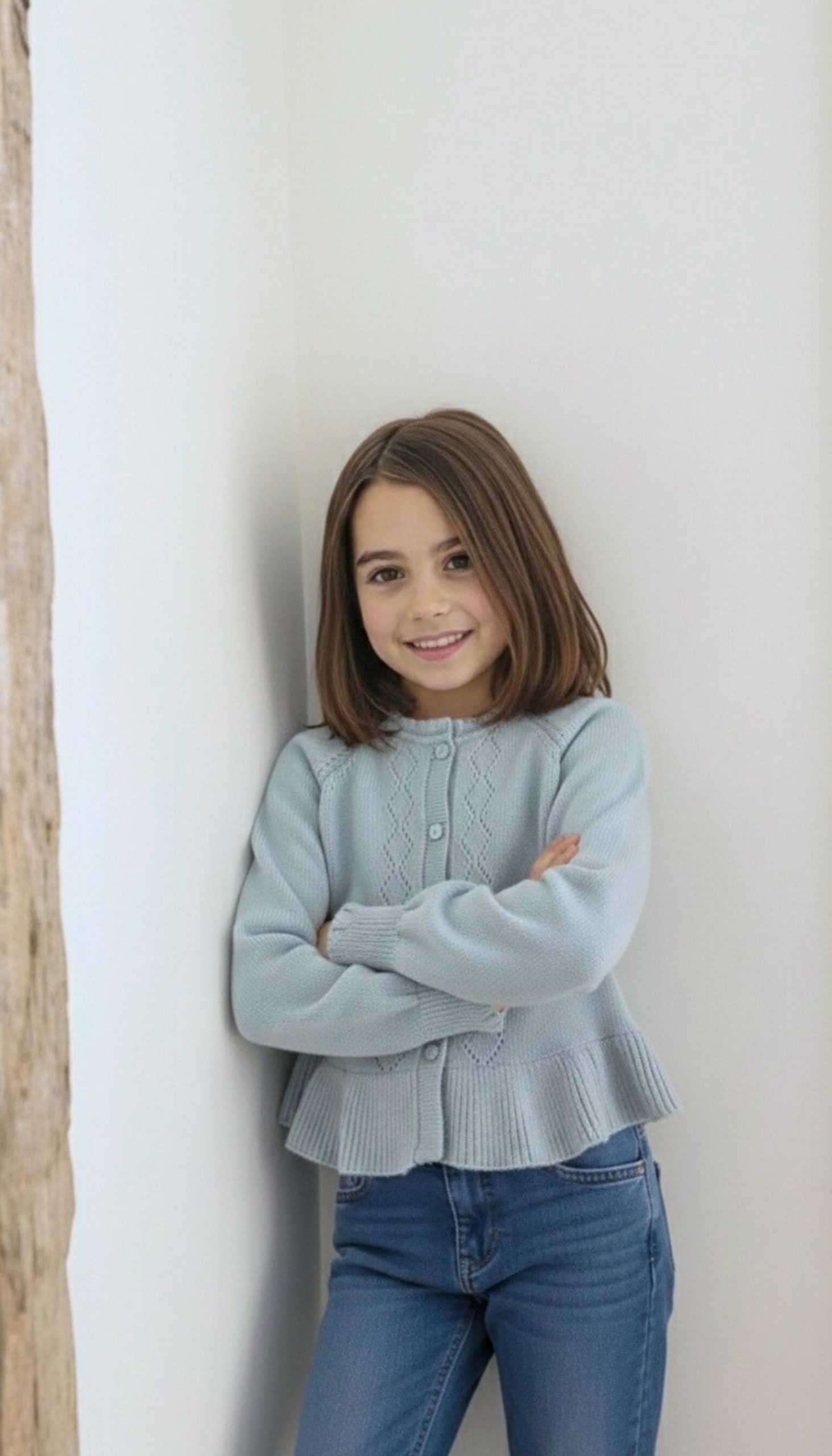 Jersey de punto azul para niña combinado con jeans en conjunto infantil.